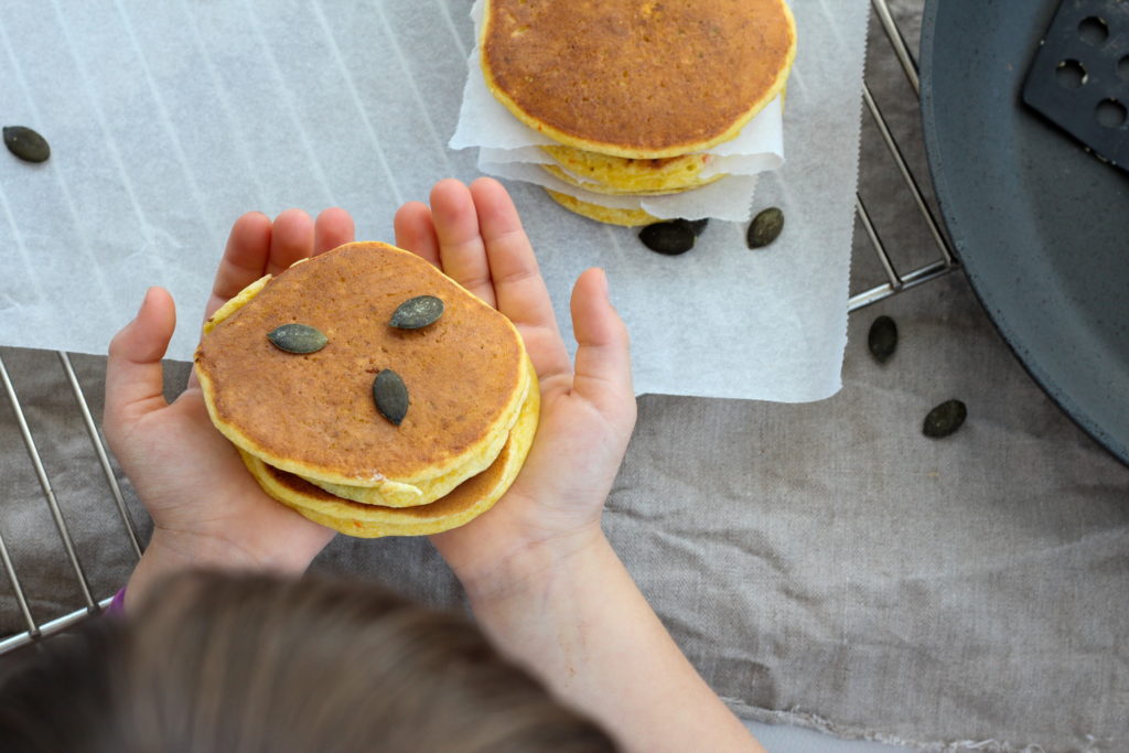 Kürbispancakes in den Händen meiner Tochter Sophia