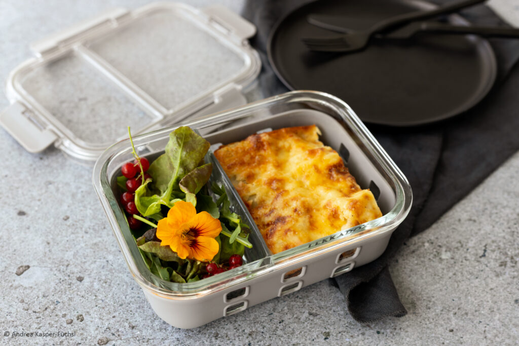 Glasbox mit Silikonhülle für Meal prep Gerichte, gefüllt mit Lasagne und Salat