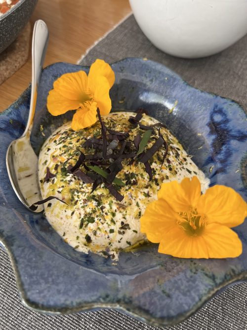 Labneh mit Gewürzen und gelben essbaren Blüten von Kapuzinerkresse